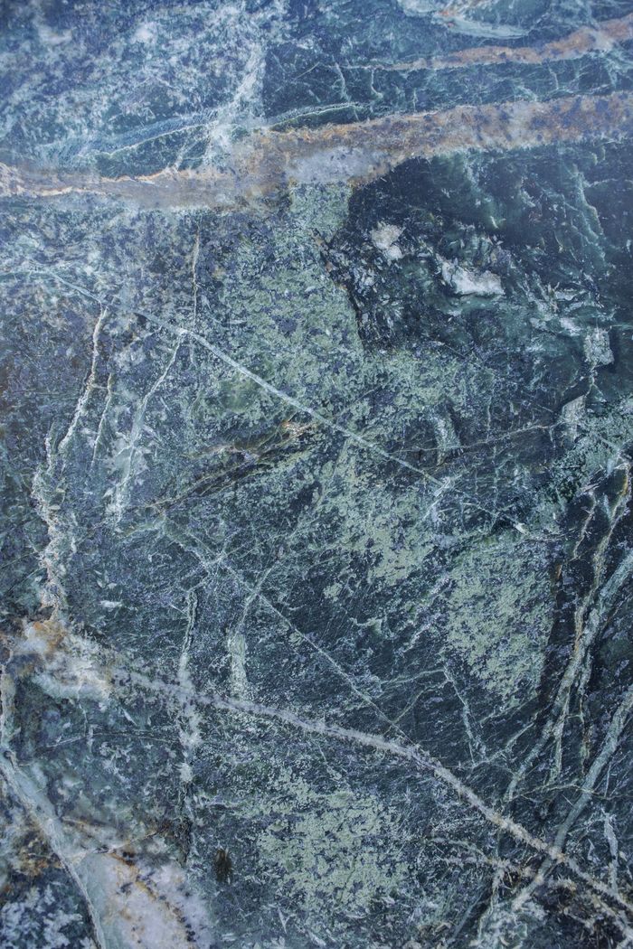 High-resolution image of a textured stone surface with natural blue-green hues and intricate patterns.